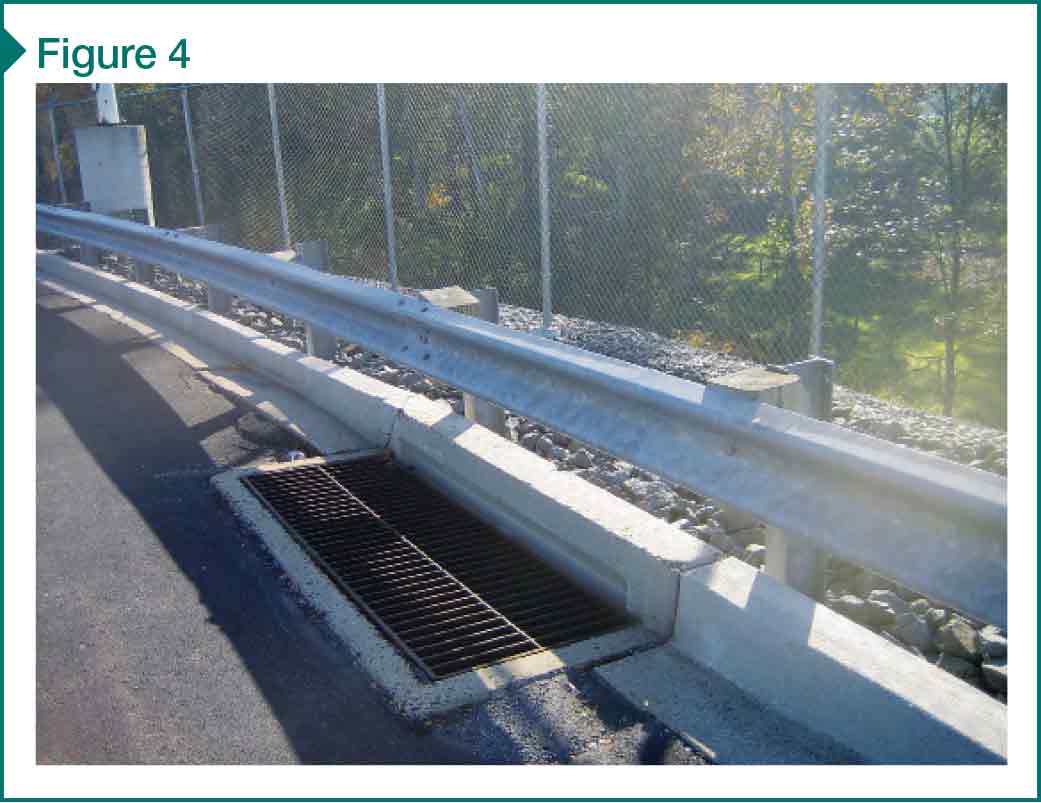 A mechanically stabilized earth wall with catch basin and light pole structure within the reinforced fill.