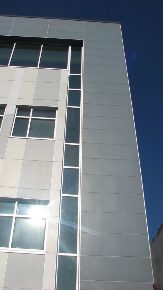 Fiber cement siding can be more durable than vinyl or wood for withstanding impacts from ice, hail, or storm debris. This image shows fiber cement siding on Lighthouse High School in the Bronx, New York.