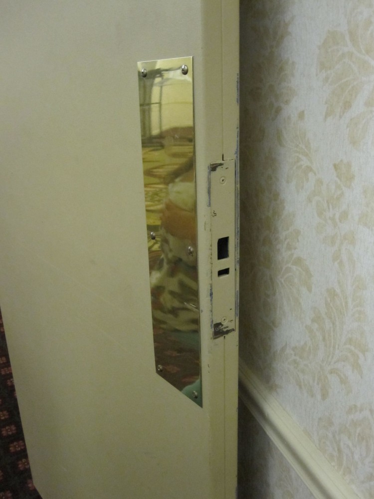 Fire doors are typically required to latch, but defective latching hardware is sometimes removed instead of replaced, as illustrated in this photo of an existing fire door in a hotel corridor.
