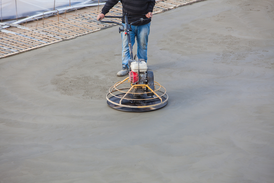 Construction worker produces the grout and finish wet concrete with a special tool. Float blades. For smoothing and polishing concrete, concrete floors ** Note: Shallow depth of field