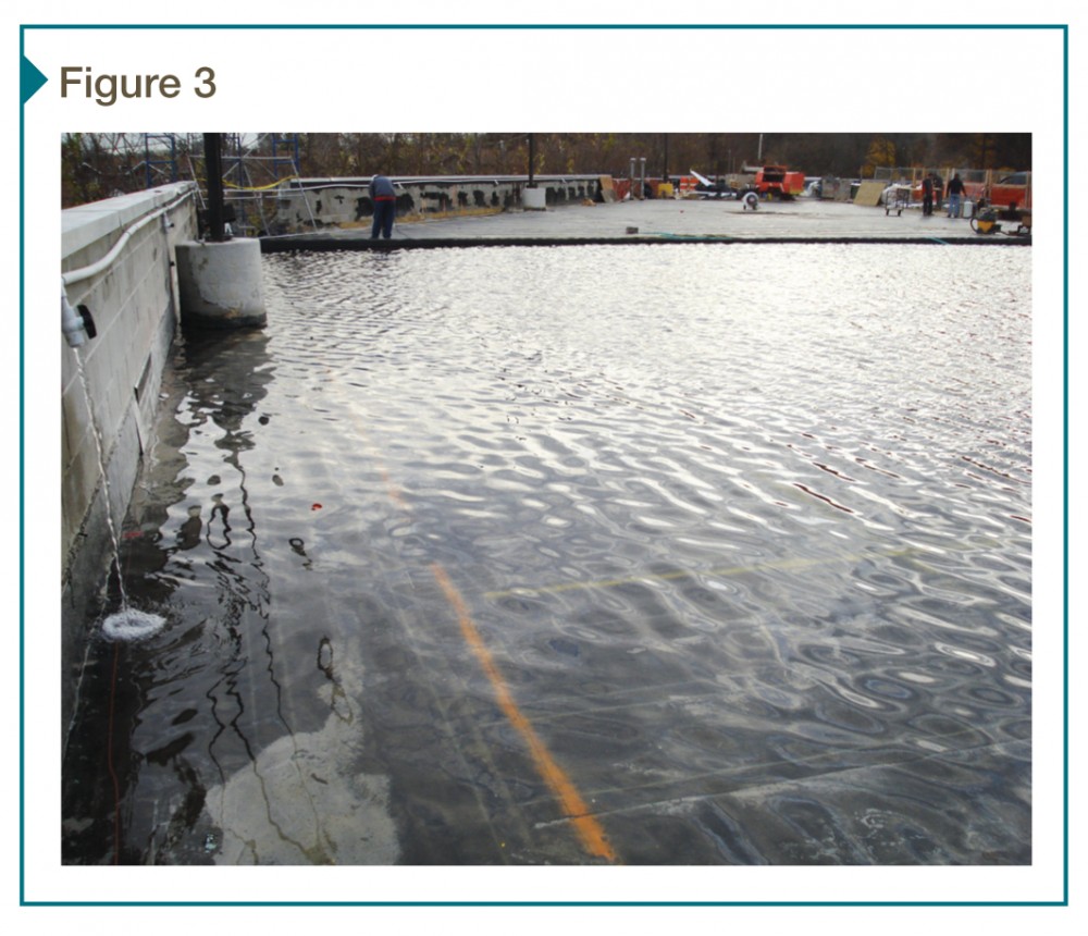 Flood testing of a membrane waterproofing system on a rooftop parking deck occurs the finished paving is installed.