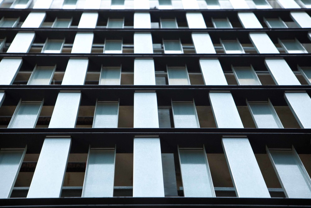 Channel glass steps around windows and doors, creating a visually engaging façade for a mixed-use residential and retail unit. All photos courtesy TGP