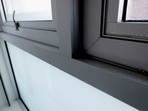 Condensation buildup on a thermally broken aluminum-framed window system in a residential building. Relative humidity (RH) levels in the adjacent living space exceeded 60 percent. Photo courtesy SGH