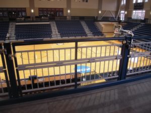 A guardrail at Berry College is locked in an upright position for safety, and folds in half for a wheelchair patron. Seats underneath the rail are lower to prevent obstructed view when standing.