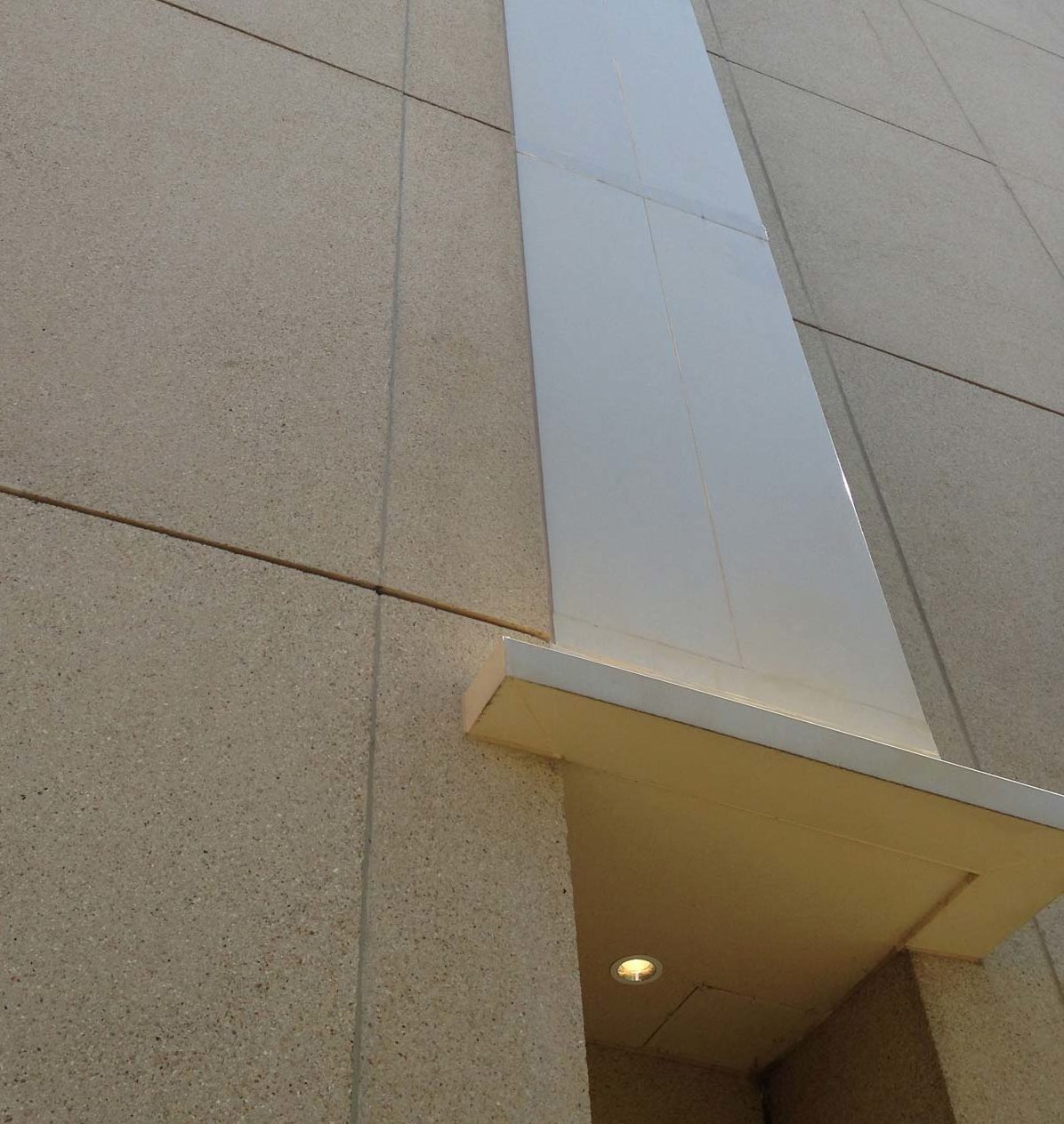 A ground-level view of the side of the building. The middle track is aesthetic acoustic panels used as ductwork to collect air from each floor and transport it to the roof.