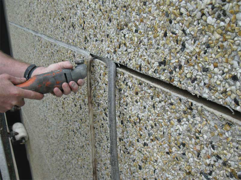 Façade sealant replacement begins with complete removal of existing sealant and backer rod.