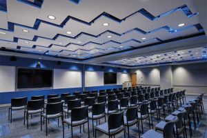 Perforated metal ceiling panels installed diagonally produce a visual reminiscent of lightning bolts at the National Oceanic and Atmospheric Administration (NOAA) facility in Grandview, Missouri.