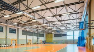 In activity rooms such as gymnasiums, the acoustic goal is to prevent excessive loudness. The design aims to ensure announcements are understandable. Acoustic treatment often needs to have abuse-resistant surfaces and be up high where they are less likely to get damaged. Photo courtesy Bartosz Makowski