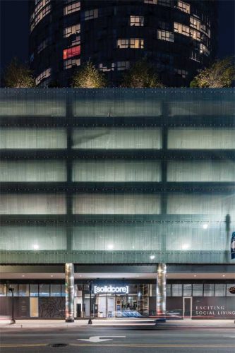 West elevation featuring ‘flat’ panel layout and a custom linear fritted pattern. The glass screens the decks, hiding views of the parked cars from the street.