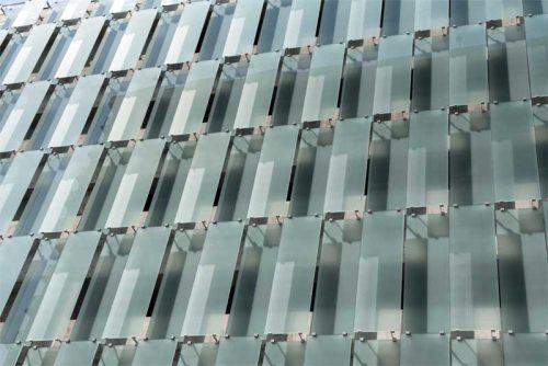 The open-ventilated north and south elevations comprise white laminated glass panels in two levels of opacity. Photos © Kelly Drake Photography