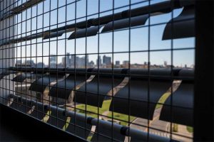 For the west garage kinetic façade system for the Boston Logan International Airport, Massachusetts, more than 48,000 square flapper panels are set within 353 extruded aluminum framing support assemblies spanning eight stories high x 88 m (290 ft) wide. Various shapes, material thickness, and finishes were tested, resulting in the curved aluminum flapper elements that reflect light and move in response to wind currents.