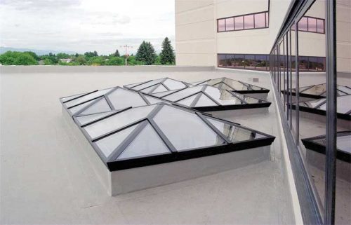 These skylights are a good example of a high-quality installation in a challenging location. The American Society of Civil Engineers/Structural Engineering Institute (ASCE/SEI) 7, Minimum Design Loads for Buildings and Other Structures, provides formulas for calculating the resulting dead, wind, snow, and other loads acting on the skylights, as does Chapter 24 of the International Building Code (IBC). The area between the wall and the skylight is especially difficult due to the possibility of drifting snow that must be accounted for in the design. Photo courtesy CrystaLite
