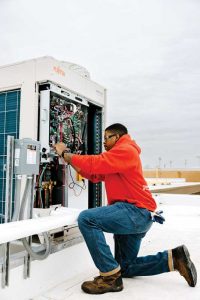 A man verifies communication between units connected to a variable refrigerant flow (VRF) system.