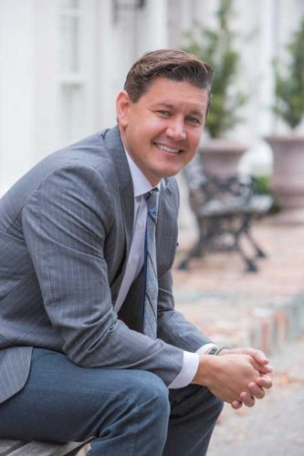 man in a suit and tie smiling at the camera