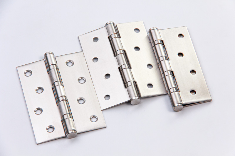 Three metallic door hinges with a brushed finish, featuring multiple mounting holes, arranged on a light background.