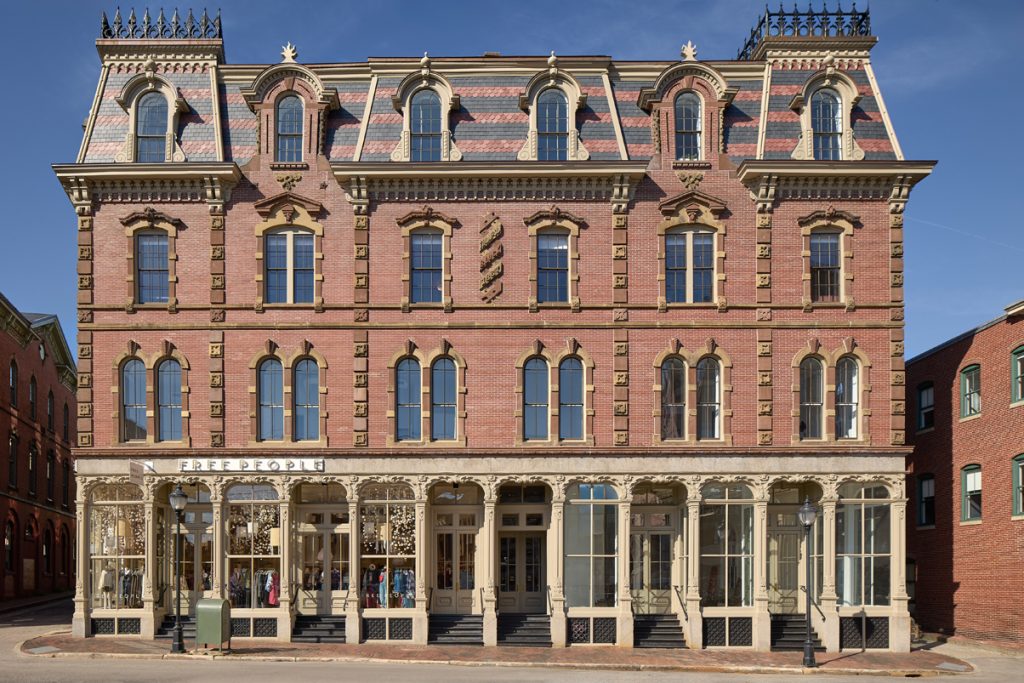 Historic red brick building with ornate architecture and a 'Free People' store on the ground floor.
