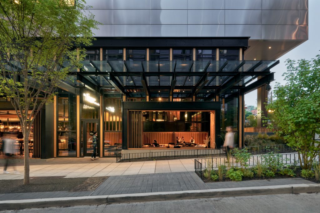 Modern building entrance featuring a sleek design and a transparent glass roof.