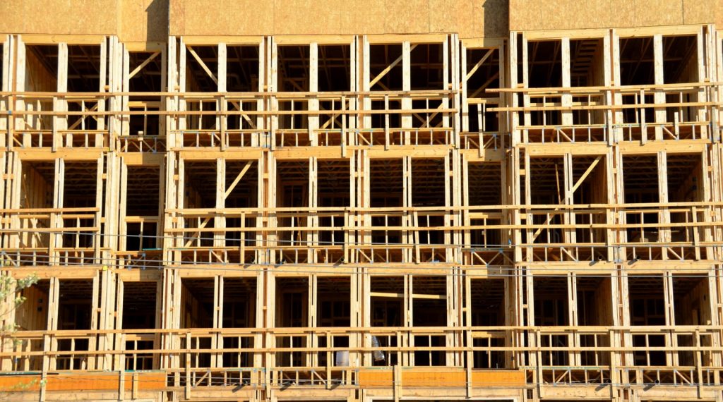 A close-up of a wooden building framework under construction, showcasing its intricate structure and scaffolding details.