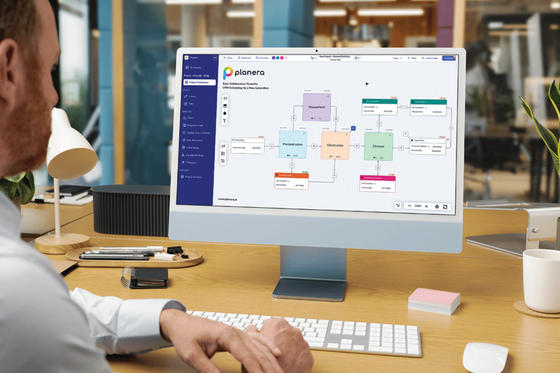 A person using a desktop computer, viewing a colorful flowchart on the screen, with a modern office background and various stationery on the desk.