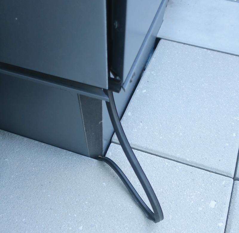 A close-up view of a gap between two surfaces, highlighted with a red arrow, revealing potential space for pest entry.