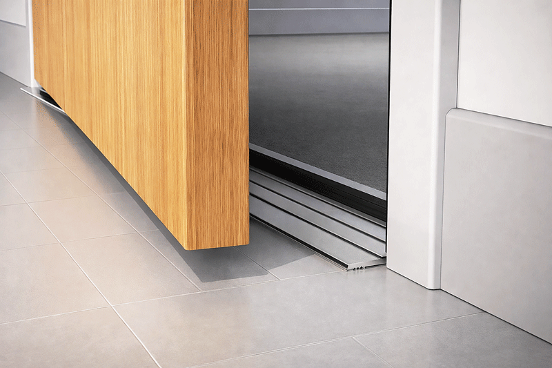 Sliding wooden door slightly open on a modern tiled floor, revealing a smooth grey interior. The scene conveys a sleek, minimalist aesthetic.