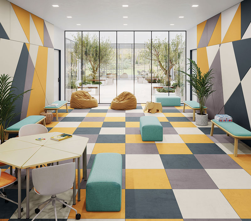 Brightly lit modern interior with geometric patterned walls and colorful tiled flooring, featuring benches, bean bags, and a table.